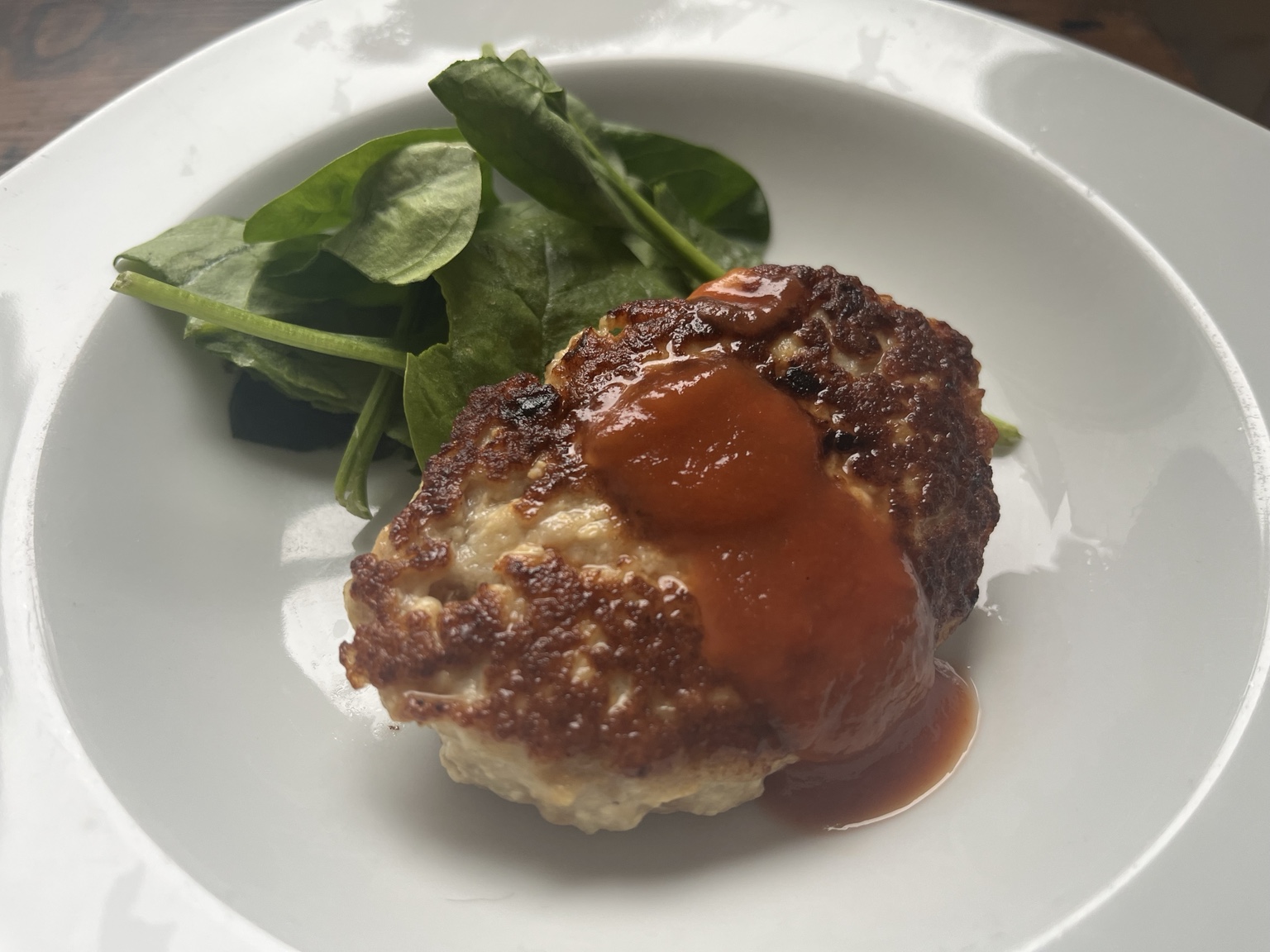 Chicken and tofu hamburg steaks with tomato sauce on a white plate