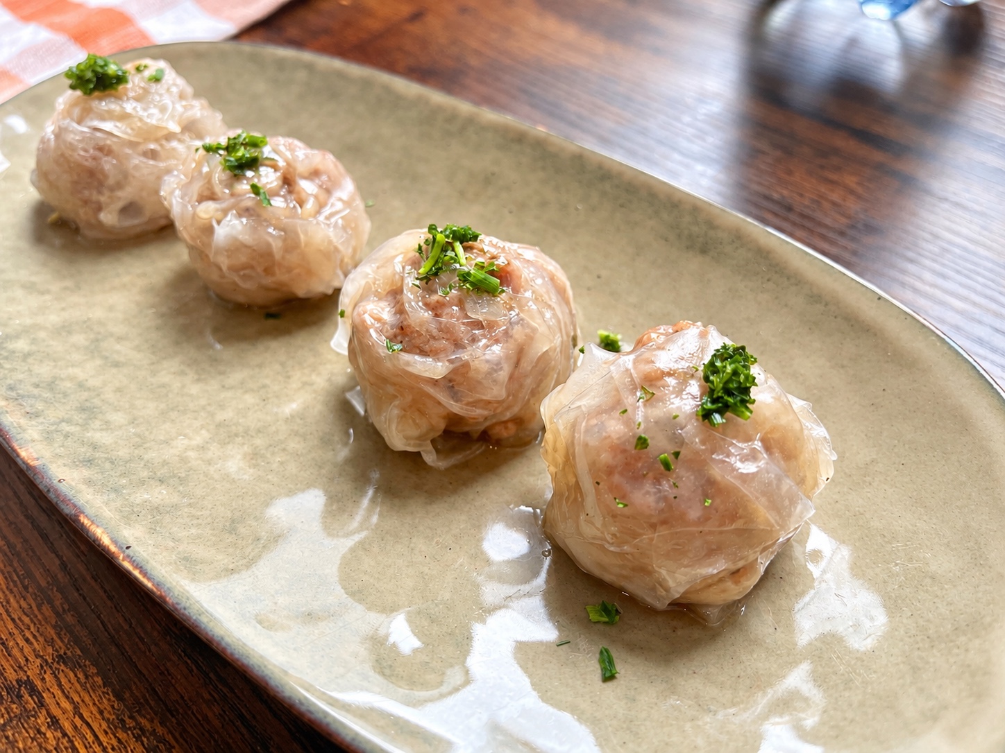 Rice paper shumai garnished with parsley on a ceramic plate